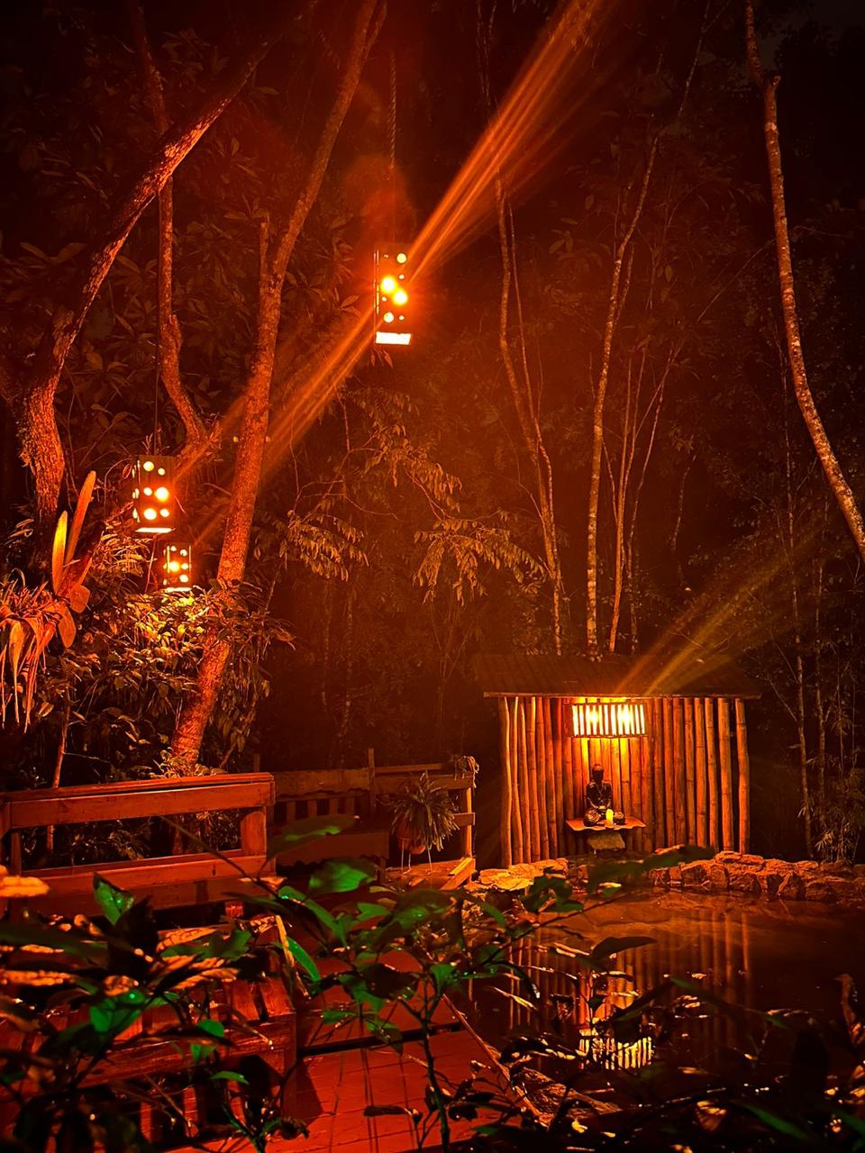 Estrutura de bambu iluminada à noite no Mauna Floresta